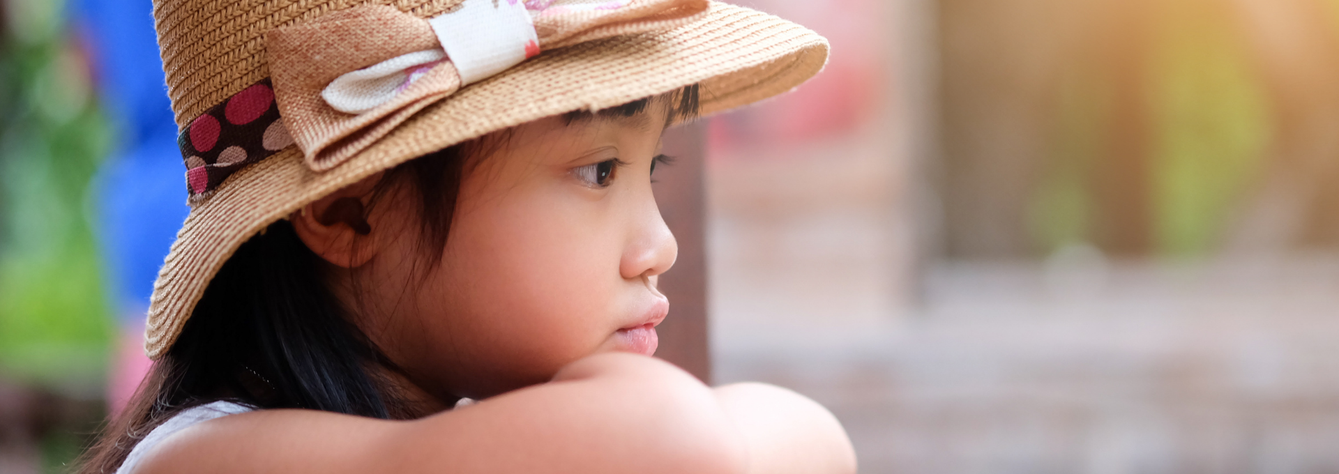 Enfant pensif portant un chapeau, le regard tourné vers l’extérieur, illustrant le stress et l’anxiété que peuvent vivre certains enfants.